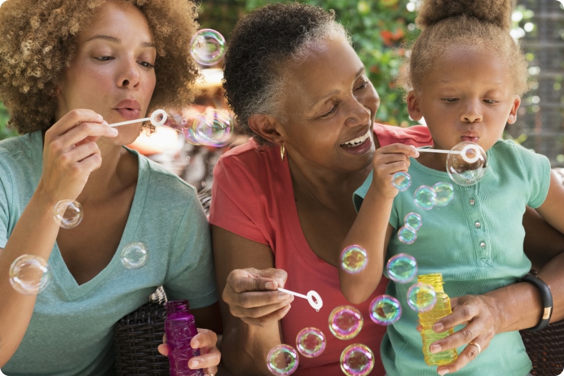 family of three making bubbles outside