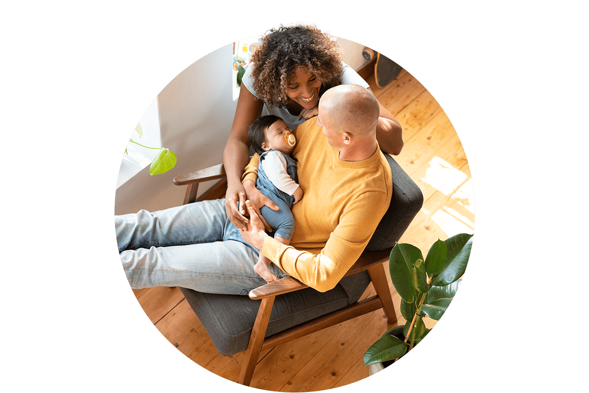 A mother and father holding their baby in a home