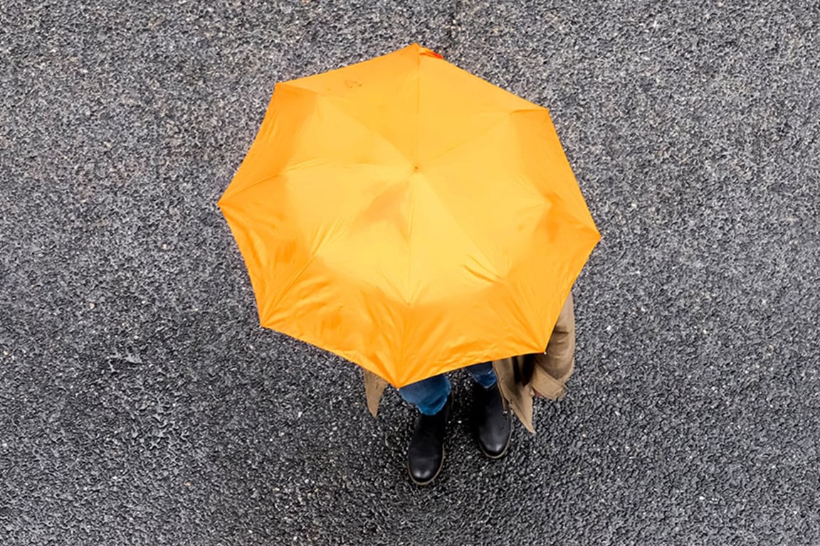 Person using a yellow umbrella