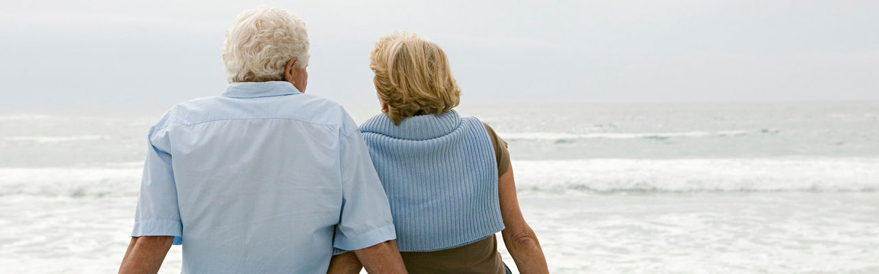 Couple sitting while looking at the ocean