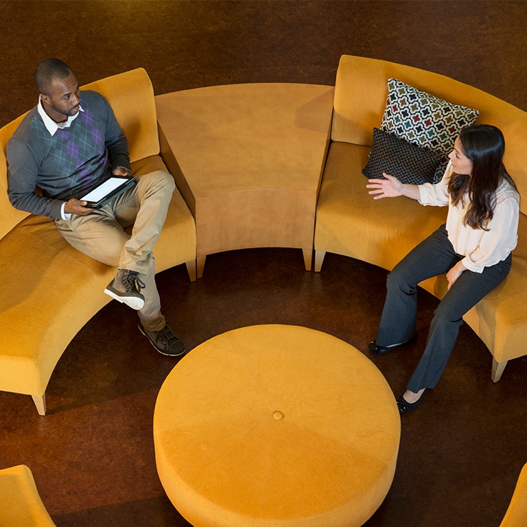 man and woman talking on a sofa
