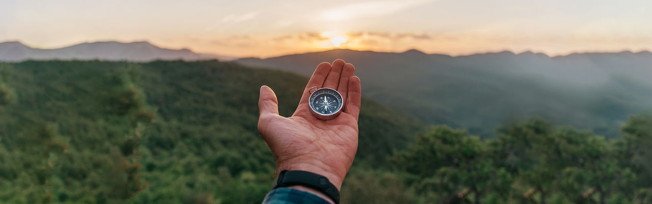 Hand holding a compass.
