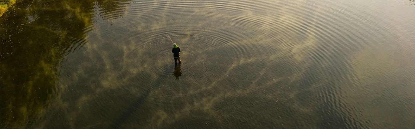 man fly fishing on river