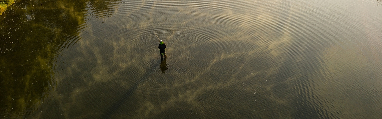 man fly fishing on river