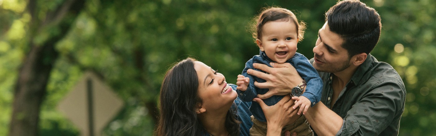 couple holding their toddler smiling