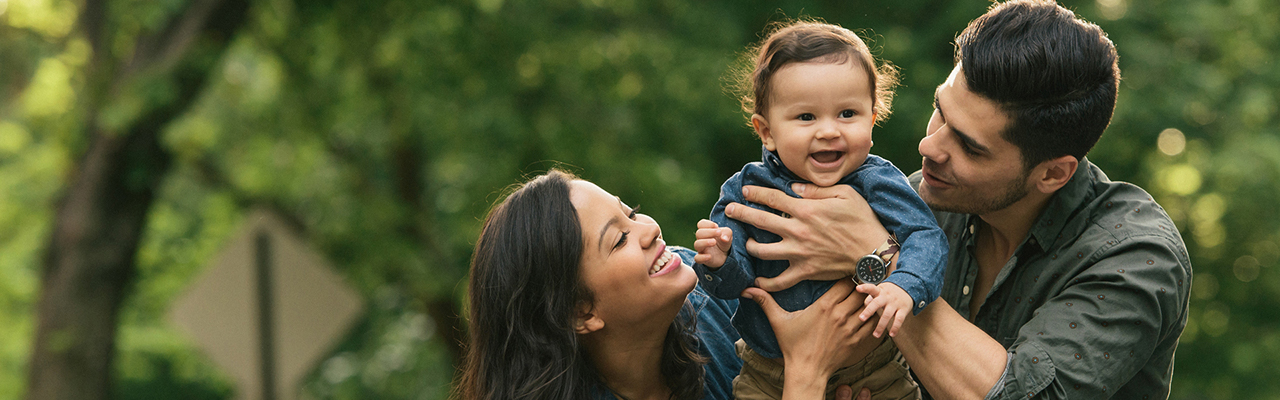 couple holding their toddler smiling