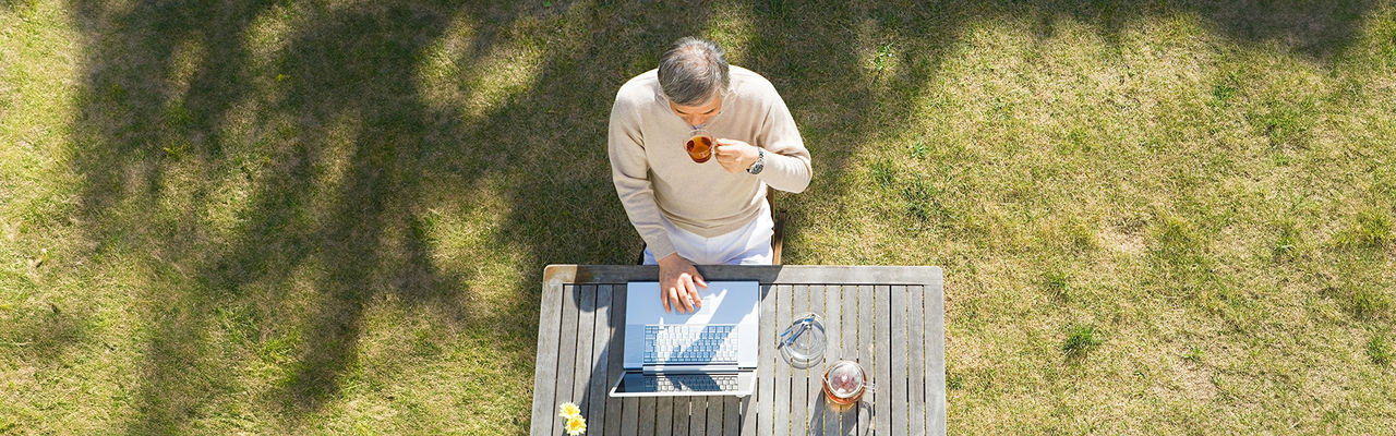 Men drinking tea while working on his laptop