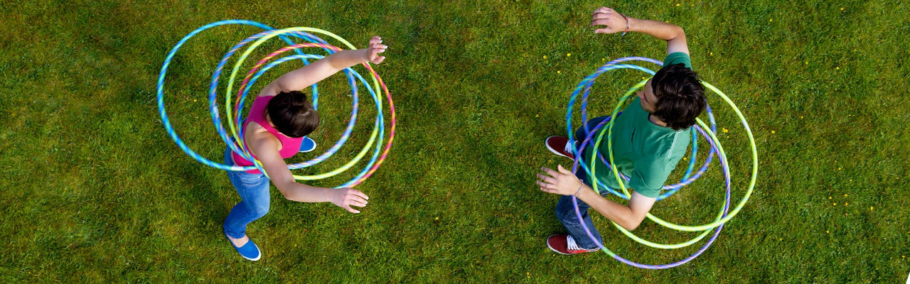 Pair hula hooping outside