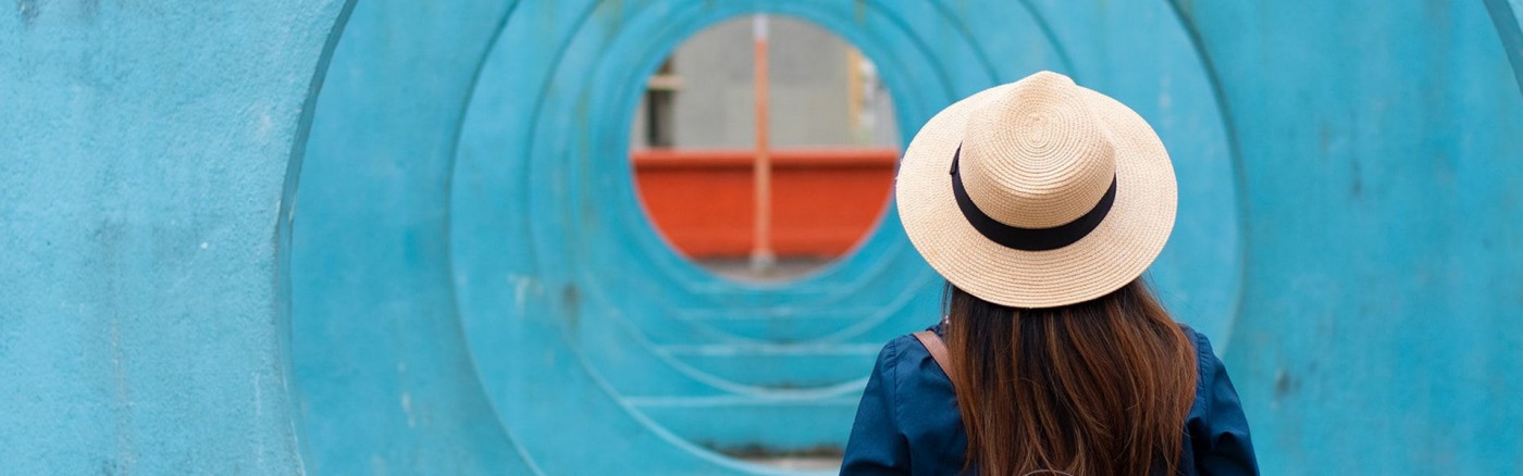 woman with hat walking away from us