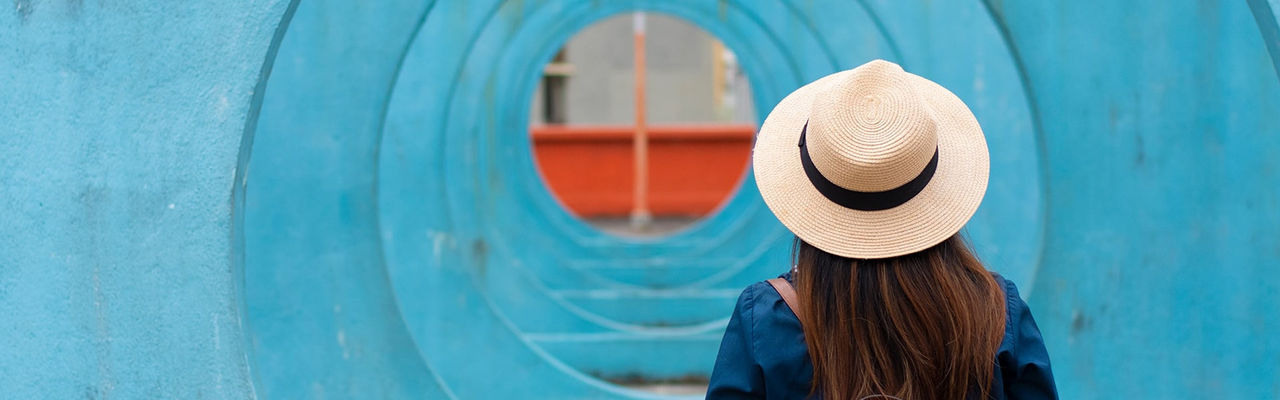 woman with hat walking away from us
