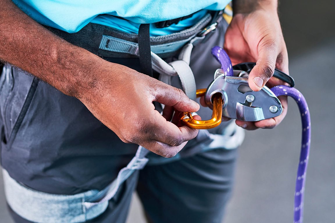person putting rock climbing harness