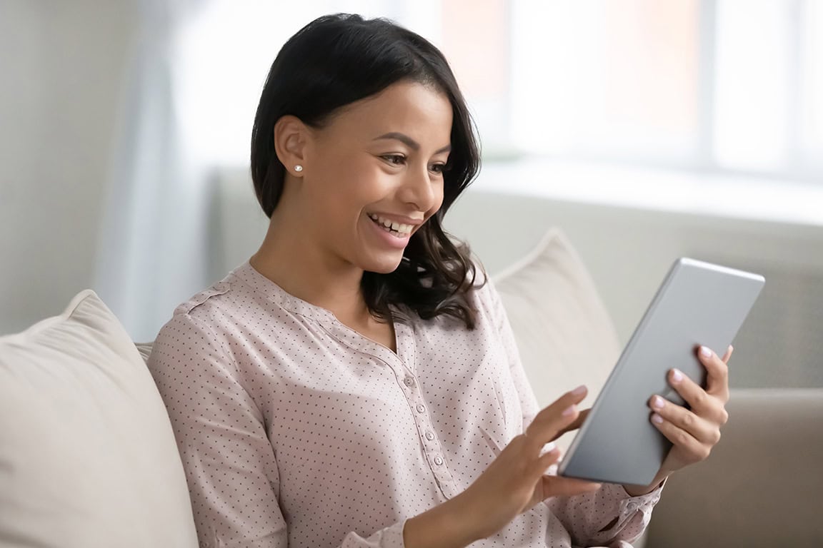 women smiling while looking at iPad