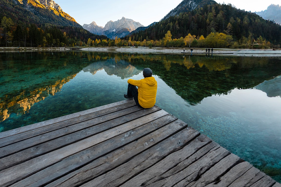 men sitting on the edge of a lake