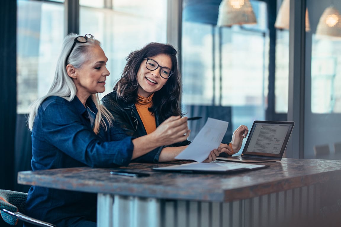 Two business women looking at a document