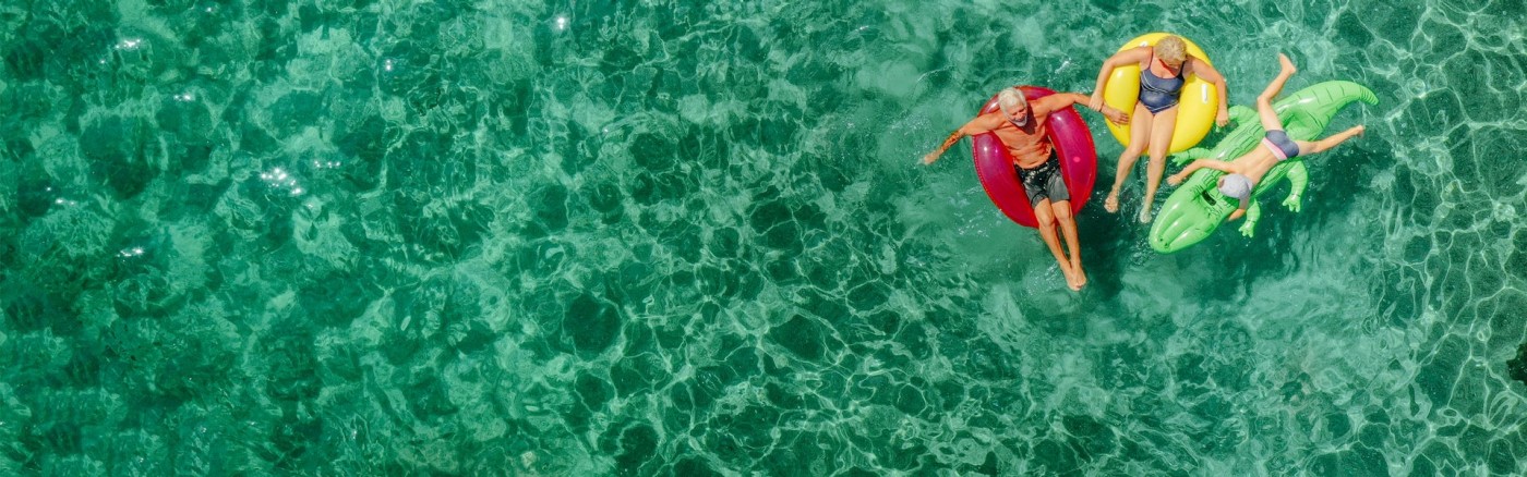 aerial view of 3 people on rafts floating in water
