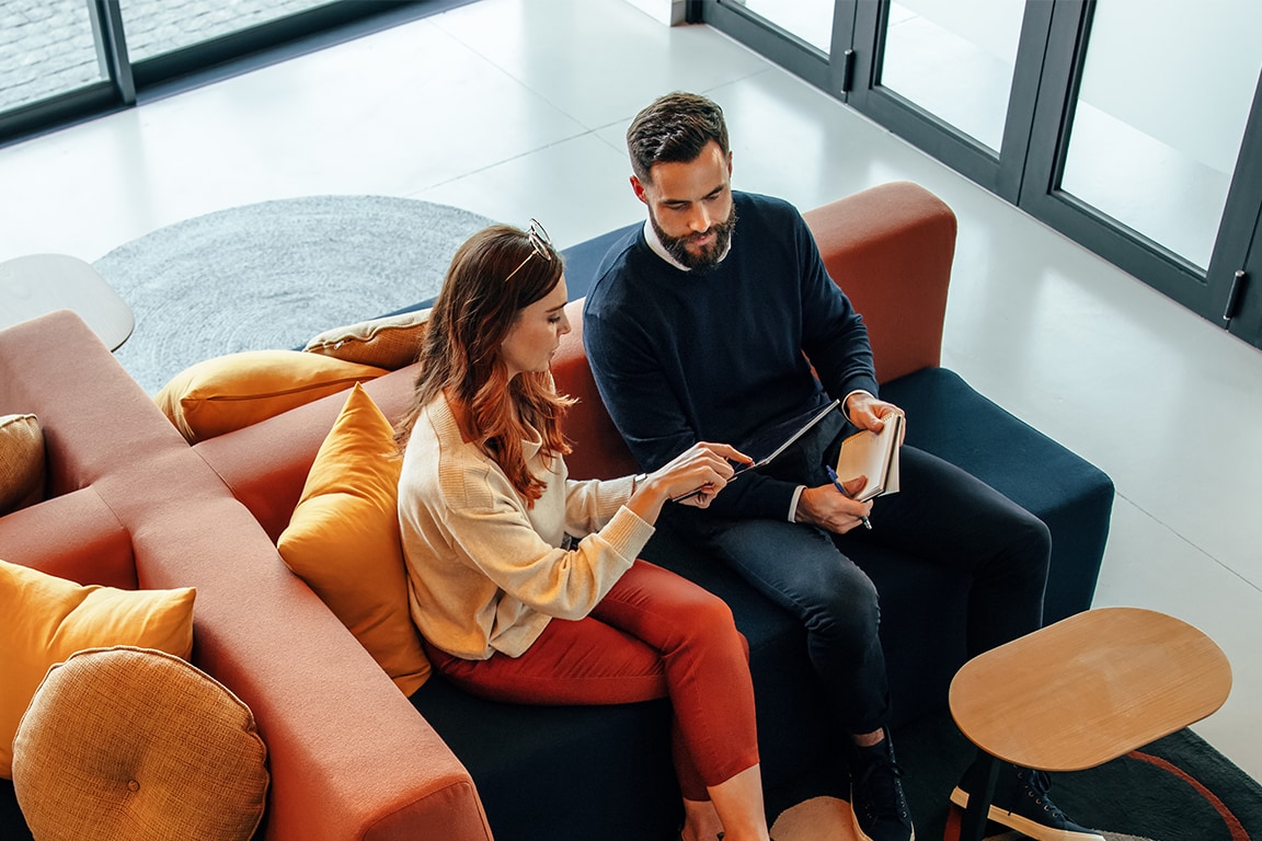 Couple sitting on a couch looking at an iPad