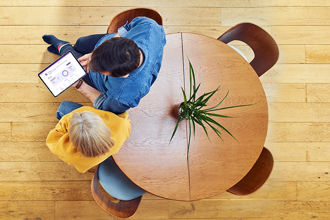 Couple reclining on a table while on ipad