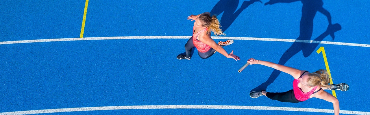 women in relay race passing the baton