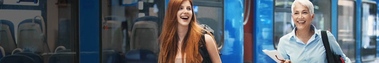 business women smiling by subway train