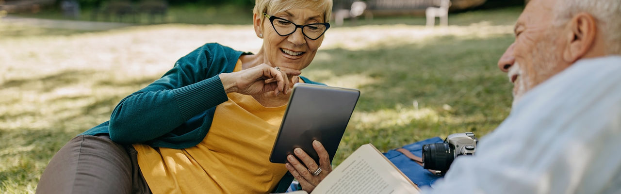 man and woman in park reading