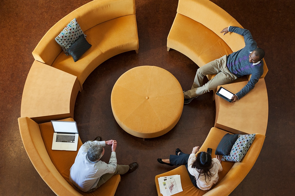 Overhead view of business people talking on circular sofa