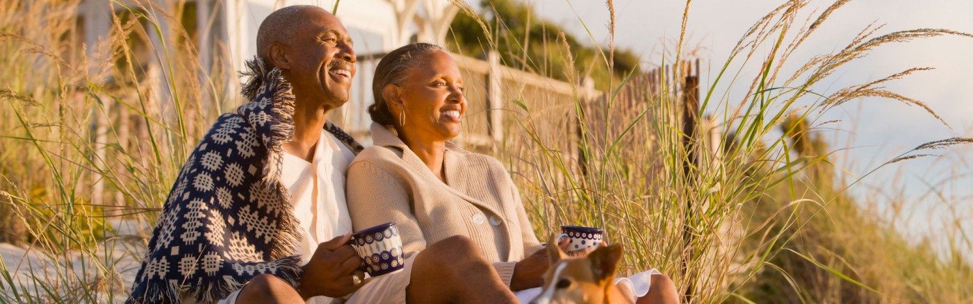 Mature couple watching sunset on beach