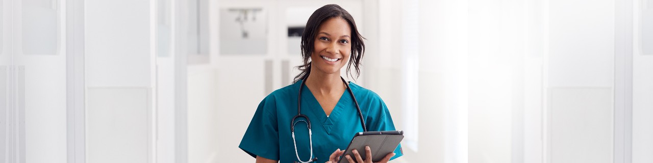 Nurse smiling while holding an iPad