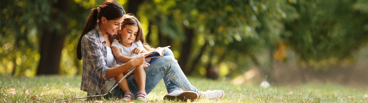 Mother reading  a book for her daughter