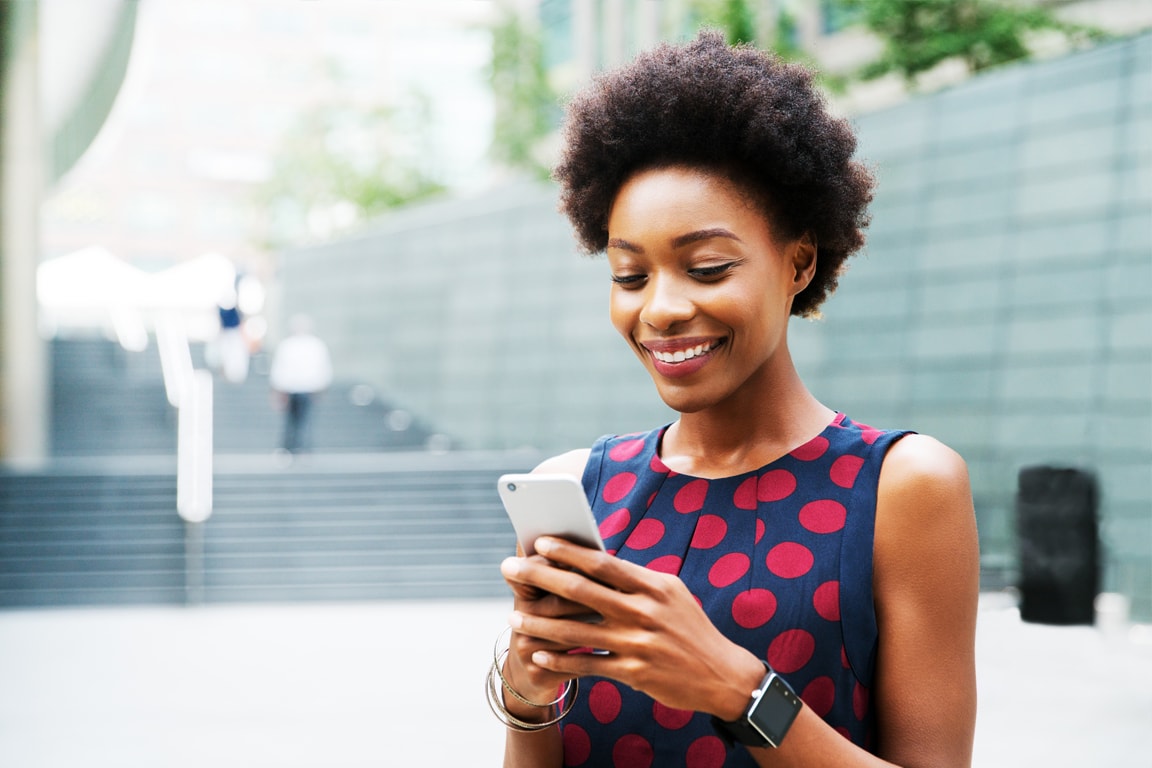 Woman smiling while looking at her cell phone