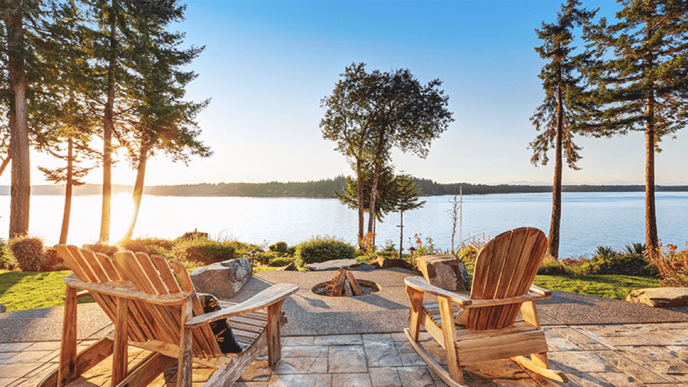 Couple of chairs in front of a beautiful lake