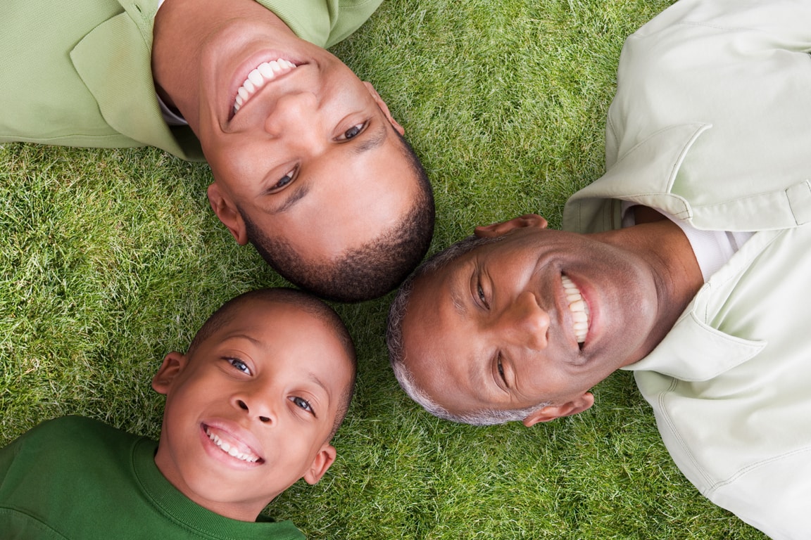 family laying on grass overhead