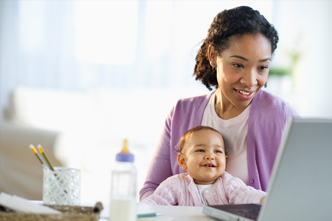 Mother and daughter smiling while looking a laptop